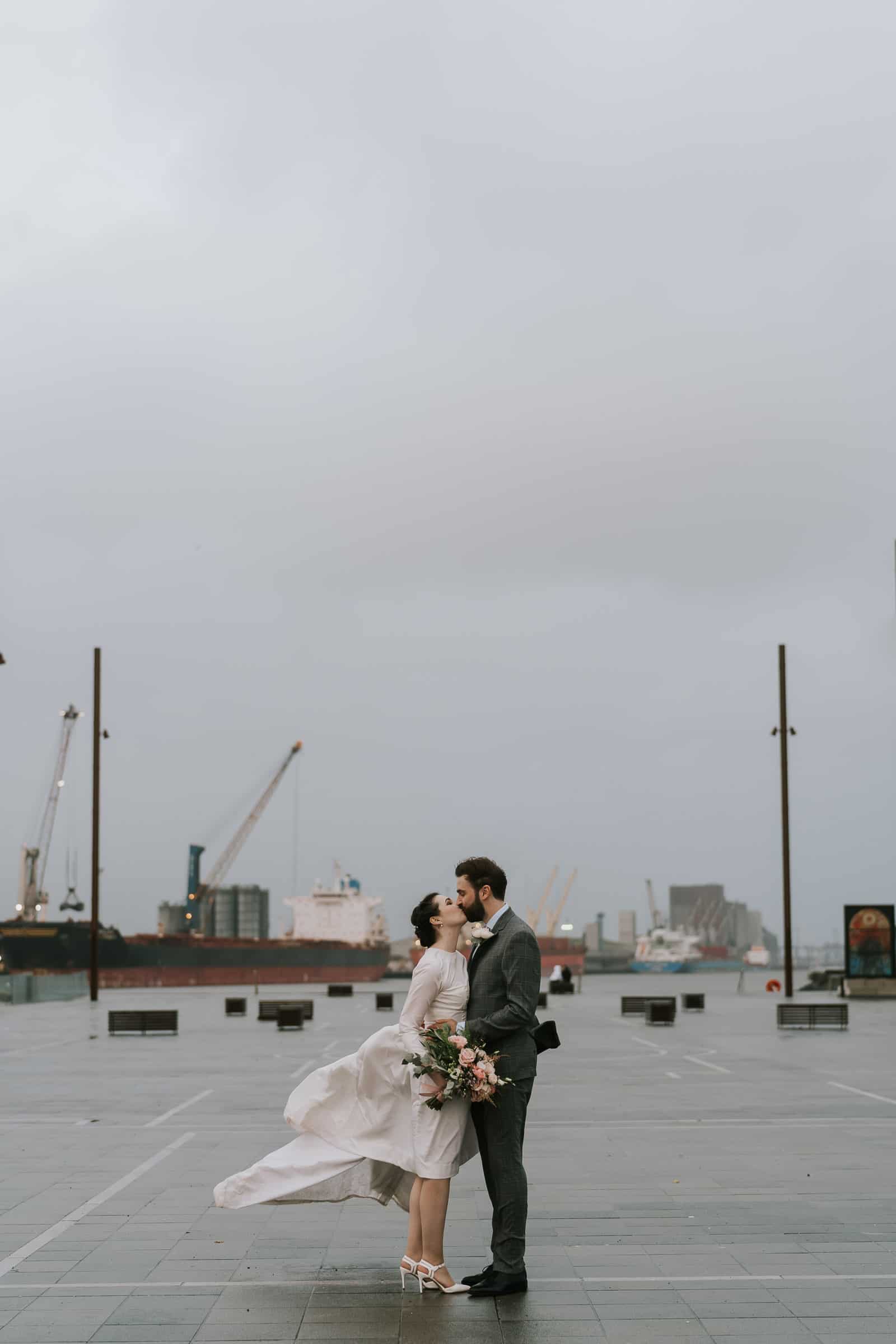 Bride and Groom kissing outside Titanic Quarter Belfast